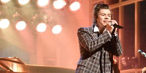 Harry Styles wearing a checkered suit performing on SNL