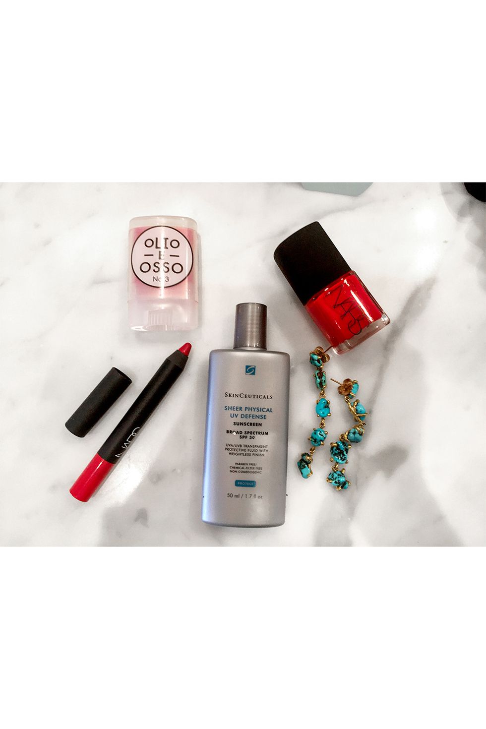<p>Counterintuitive, I know, but to me nothing says summer like head-to-toe red. I'm obsessed with natural beauty brand Olio E Osso's crimson-tinted, olive oil–based lip balm for a subtle wash of color. For a bold lip, Nars's lip pencil is as easy as a Crayola. Nars's red is also pedicure perfection (I only wear polish in the summer), and turquoise drop earrings add swing and color. I use SkinCeuticals SPF 50 on my face every day; every makeup artist on location shoots tells me it's the best.
</p><p><i data-redactor-tag="i">Clockwise from top left: OLIO E OSSO Cheek and Lip Balm in No. 3 Crimson, $28. NARS Nail Polish in Dovima, $20. Turquoise earrings, LISA EISNER JEWELRY, $1,400. SKINCEUTICALS Sheer Physical UV Defense SPF 50, $34. NARS Velvet Matte Lip Pencil in Dragon Girl, $27</i></p>