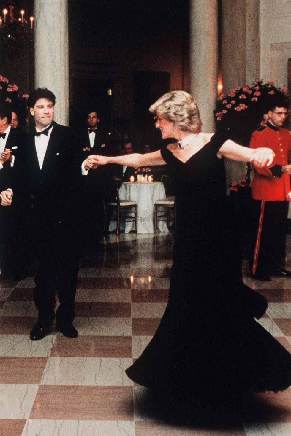 <p>This Victorian-inspired gown became almost as famous as Diana's dance partner in this photo, a young John Travolta.&nbsp;</p>