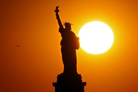 The sun sets behind the Statue of Liberty on June 02, 2017 in New York City