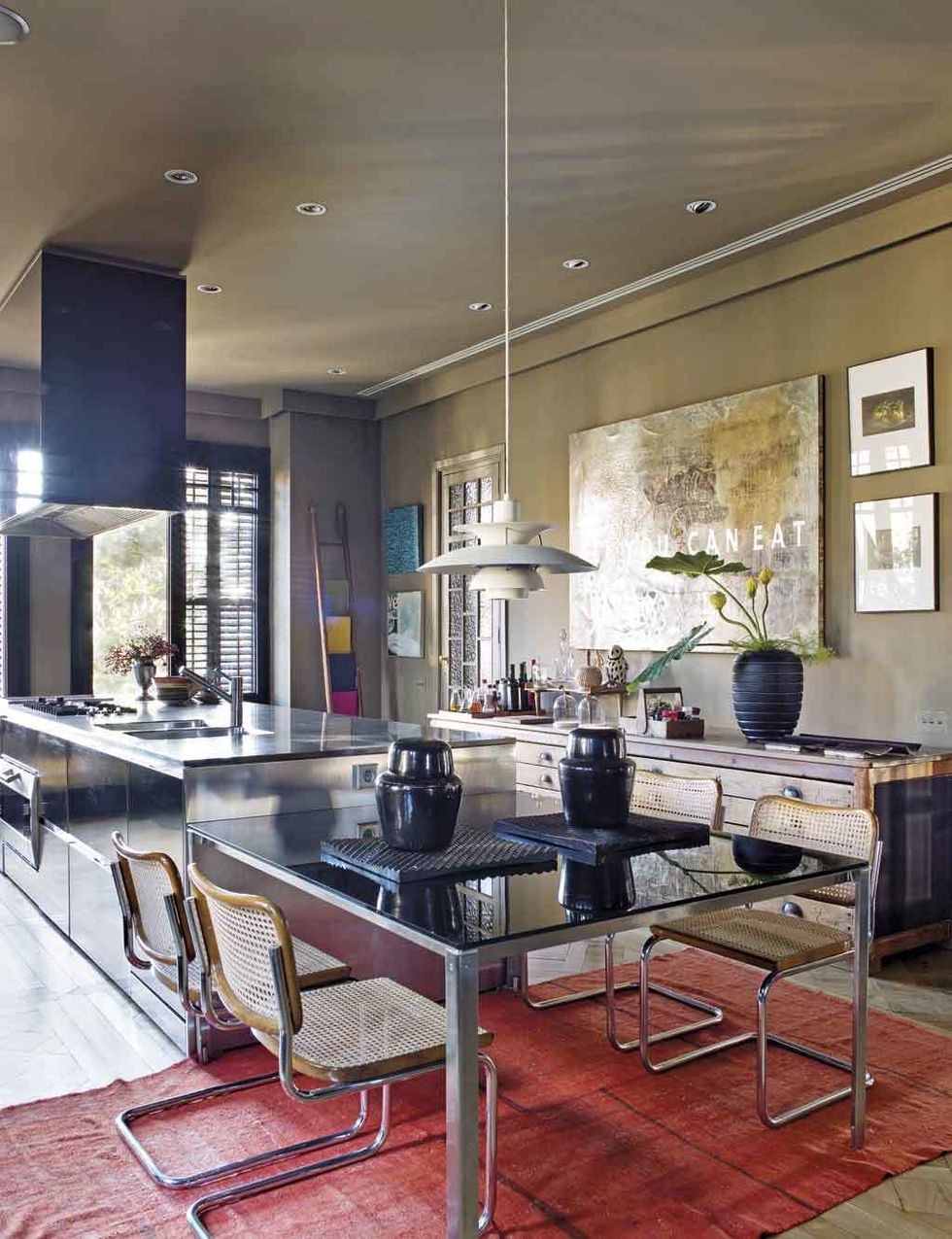<p>Un mueble futurista, de Boffi+Foster, al fondo, y clásicos del diseño, la lámpara <i>PH50</i>, de Poul Henningsen para Louis Poulsen, y las sillas <i>Ceska</i>, un icono modernista, de Marcel Breuer que edita Knoll, se combinan en la cocina con un antiguo mueble de tahona. El cuadro es de Rafael Adrover, y la alfombra, de A Casa Bianca.&nbsp;</p>