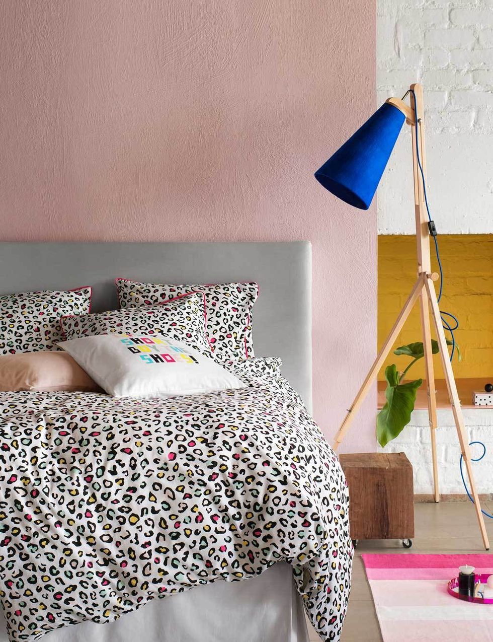 <p>Literalmente, porque en este dormitorio el descanso se hace muy goloso, gracias a la pared en rosa palo y el cabecero gris nórdico. El punto de color lo pone la lámpara, con pantalla en azul klein, y la ropa de cama con print felino, de H&amp;M Home.</p>