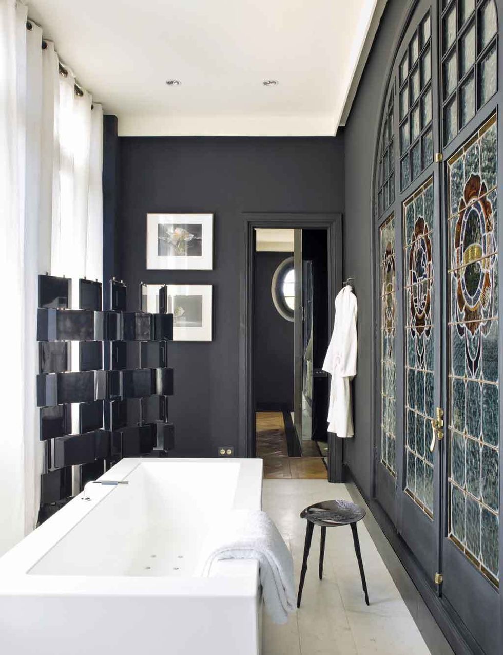<p>En el cuarto de baño, en <i>black &amp; white,</i> bañera de hidromasaje Kos y suelo de mármol. Junto a la bañera, taburete de latón acabado en bronce y trabajado en fundición. Lo enmarcan vidrieras originales restauradas.</p>
