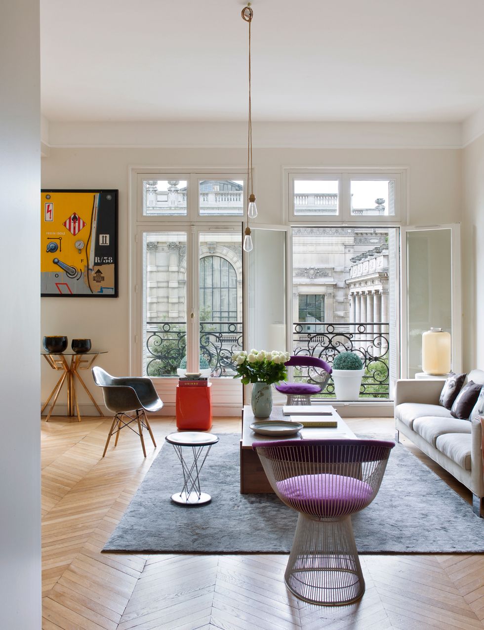 <p>Pero no a los de la propia casa, sino a los del Palais Galliera. En morado, el sillón <i>Side Chair</i>, de Warren Platner para Knoll; y en negro, la <i>Eames Plastic Chair</i>, editada por Vitra. La mesa auxiliar naranja <i>Oko</i> es de Christophe Delcourt. En la pared, cuadro de Peter Klasen.&nbsp;</p><p>&nbsp;</p>