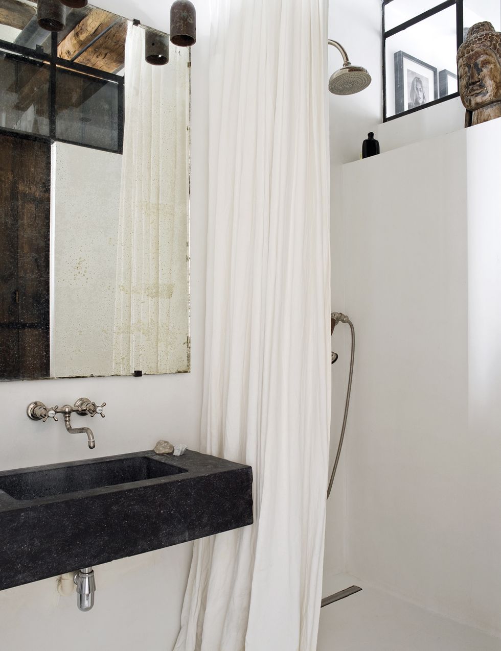 <p>El cuarto de baño es un espacio sencillo, funcional, bien aprovechado y con un toque de encanto, gracias al espejo y a la grifería antiguos, ambos procedentes de mercadillos. Las lamparitas son de Chez Merci.</p>