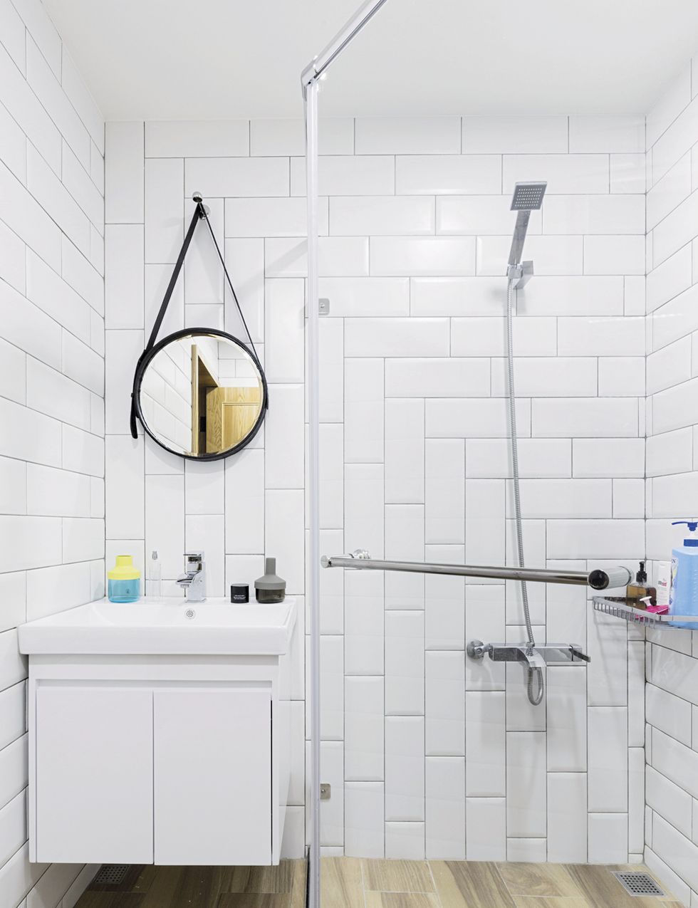 <p>En el baño se combinan azulejos blancos con un suelo cerámico que imita madera, todo comprado en Cheng Feng. El lavabo y el conjunto de ducha, de Nobel. Floreros <i>PS 2014</i>, de Ikea.&nbsp;</p>