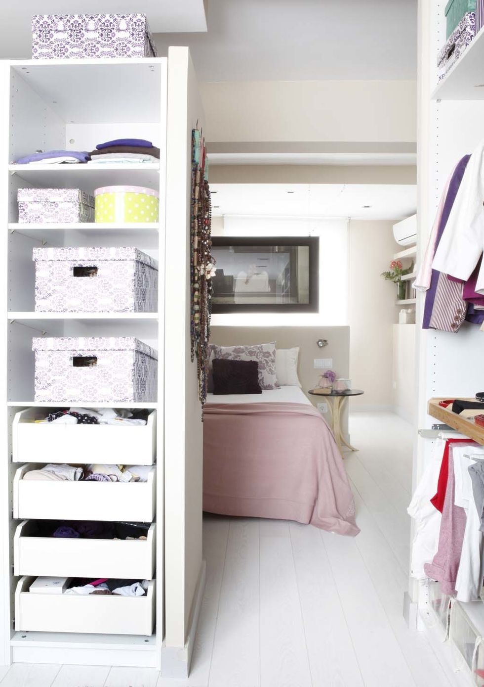 <p>Si tienes un dormitorio grande, convierte la mitad del espacio en vestidor con unas cuantas estanterías de almacenaje como proponen en esta práctica idea. Cajas y cajones harán el resto.&nbsp;</p>