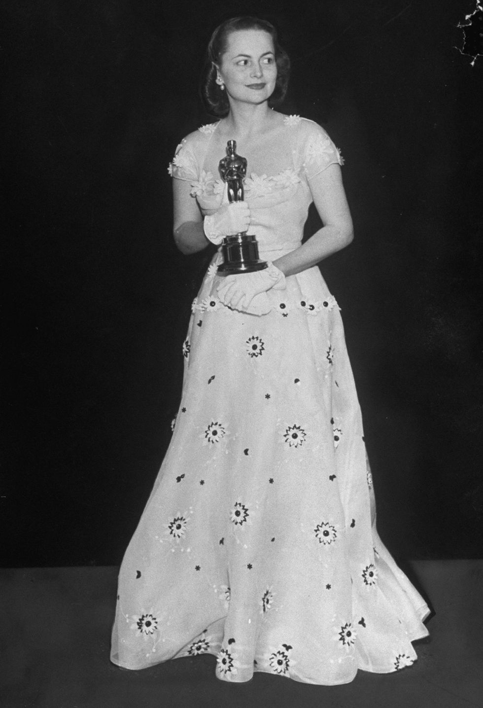 <p>Segundo Oscar para la inolvidable Melania de 'Lo que el viento se llevó'. En esta ocasión, fue 'La heredera' (William Wyler, 1949) el filme que le llevó al Pantages Theater de Los Angeles con este look de <strong>Orry Kelly,</strong> un vestido blanco con apliques florales.</p>