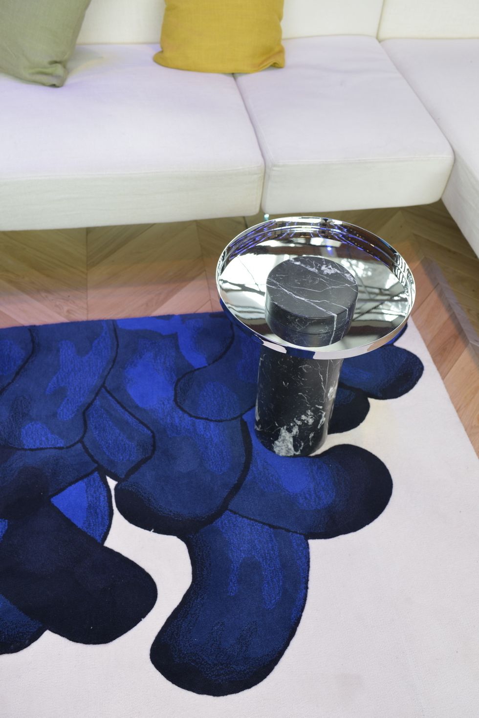 <p>Sobre la alfombra, una <i>coffee table</i> de mármol y cristal.</p>