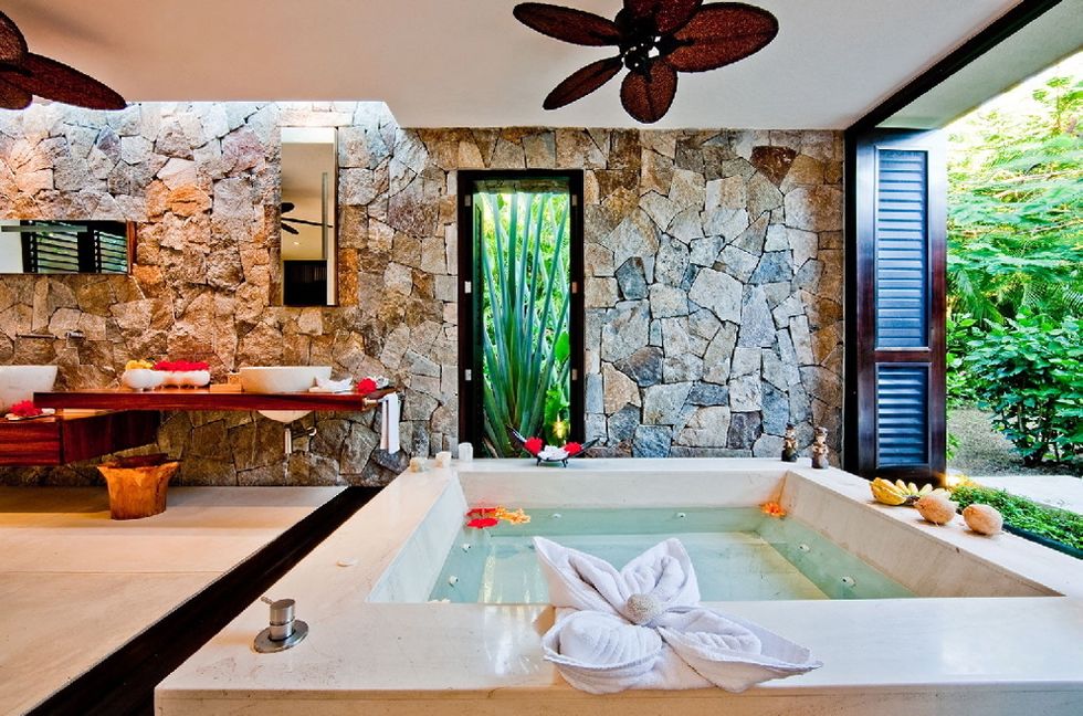 <p>La exuberante vegetación de Nayarit (México) se cuela en este baño, perteneciente a una villa llamada Casa Kalika. La bañera de mármol con hidromasaje ofrece unas vistas privilegiadas.</p>