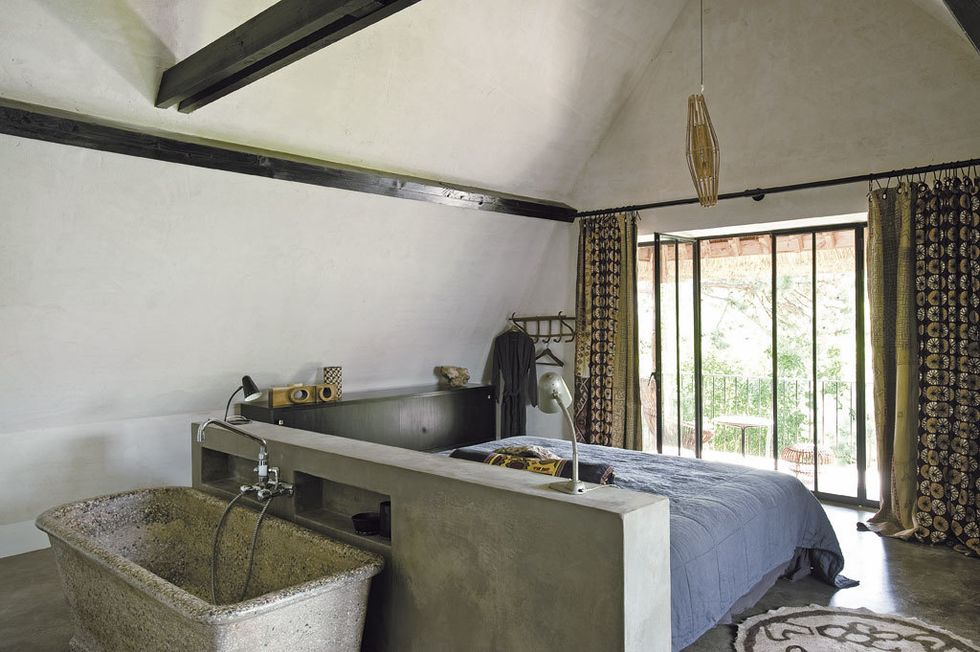 <p>Aparador negro, de Martin Visser; alfombra, lámpara de bambú y cojines adquiridos en Turquía; bañera exenta de piedra,  de Dominique Desimpel.</p>
