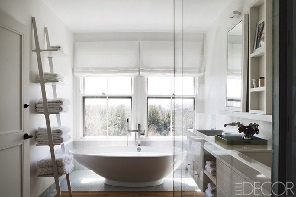 <p>Una estantería de pared, diseñada por Ascher Davis Architects, es la protagonista de este baño, perteneciente a una casa de vacaciones en Nantucket. La grifería del lavabo es de Lefroy Brooks, y la de la bañera, de Dornbracht.</p>
