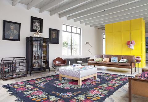 <p>Un armario amarillo divide espacios en el salón y contrasta con los sofás de cuero de los 60, de Hans Olsen para CS Glostrup. Lámpara de pie, de Piet Hein Eek, y jaula de madera, prototipo de Dick van Hoff. En la alfombra moldava, una mesa vintage de los 50, recuperada  y tapizada con piel de avestruz.&nbsp;</p>