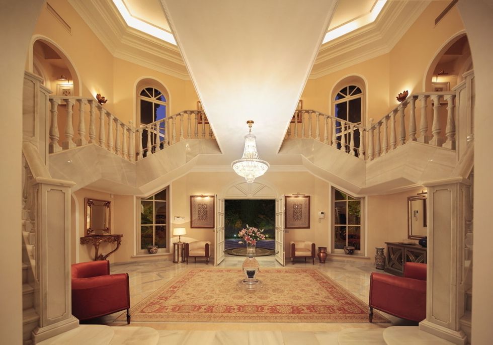 <p>Una doble escalera de mármol con una espectacular balaustrada que confluye en torno a una <i>chandelier</i> da la bienvenida a la casa. </p>