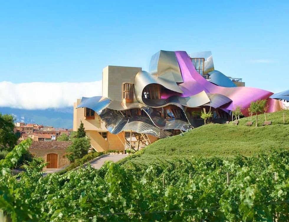 <p>
El espectacular diseño de su edificio, de arquitectura vanguardista, está firmado por Frank O. Gehry. El canadiense quiso plasmar los colores representativos de los vinos Marqués del Riscal -rosa, oro y plata-, y aportar un toque futurista con un revestimiento de titanio. No es de extrañar que haya sido escenario de numerosas producciones de moda.<br /><a href="http://www.hotel-marquesderiscal.com" title="Hotel Marqués de Riscal Elciego" target="_blank">www.hotel-marquesderiscal.com</a></p><p>&nbsp;</p>