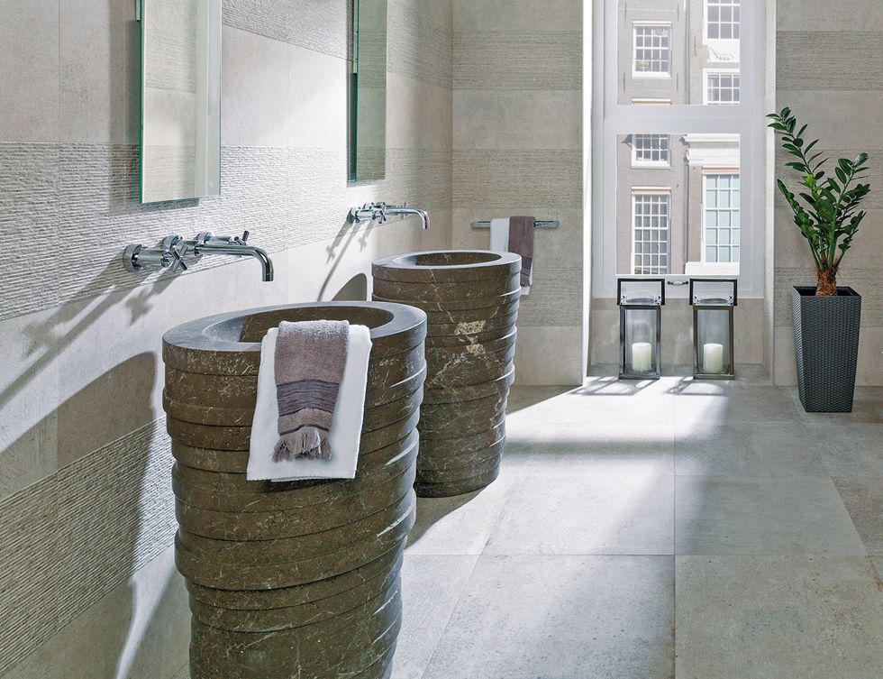 <p>Los lavabos <i>Azrama</i> de piedra, 6.703 €/cu, son de L'Antic Colonial (Grupo Porcelanosa). Revestimiento <i>Park Lineal Acero,</i> desde 50 €/m2,  de Porcelanosa.</p>