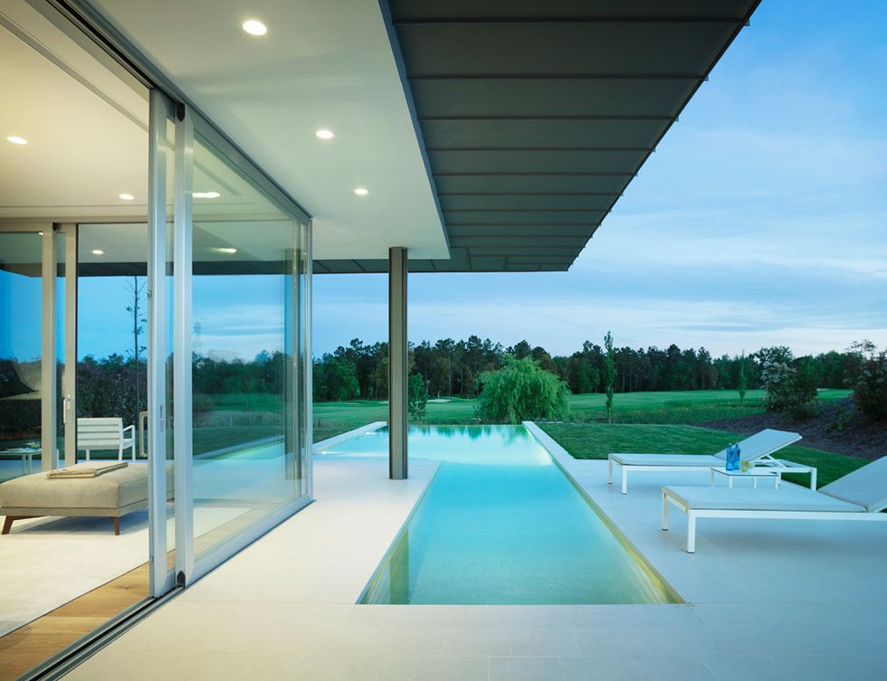 <p>Integrada en la terraza solarium, la piscina desbordante parece formar parte del salón, separado visualmente tan sólo por una amplia corredera de cristal. Dos grandes terrazas, un porche y una barbacoa-<i>kitchenette</i> rodean la piscina.</p>