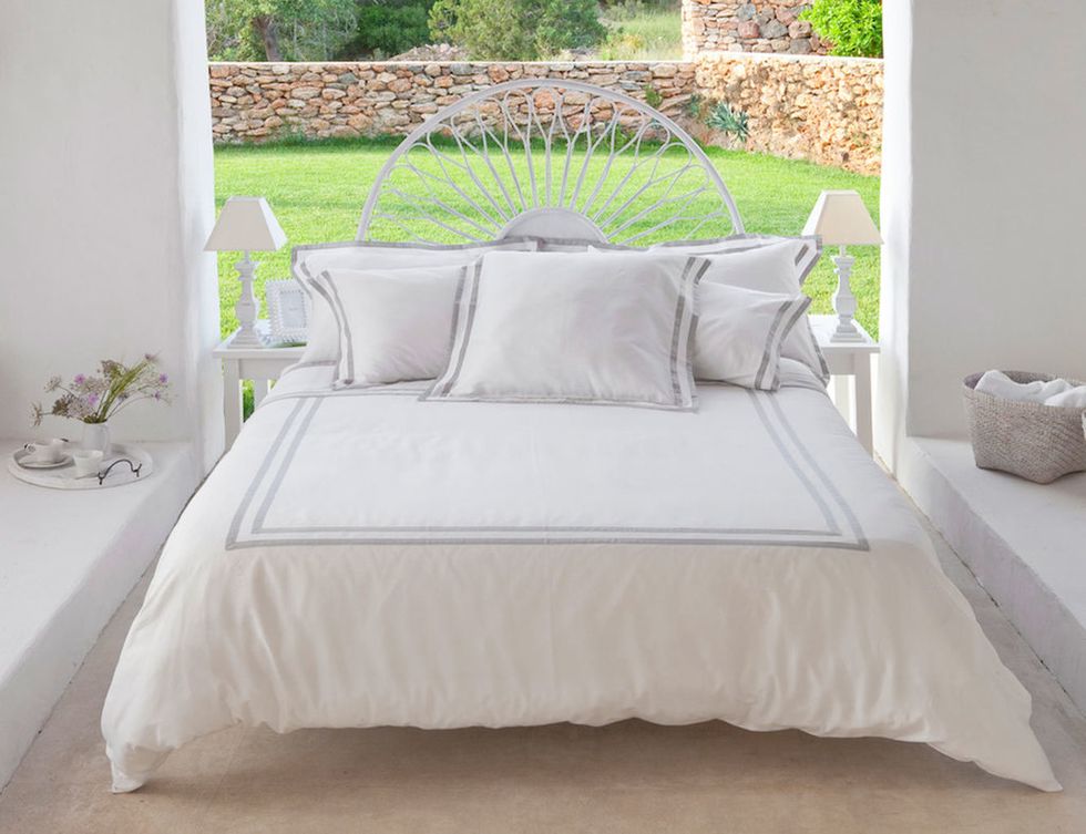 <p>La ropa de cama en tonos blancos, de Deia Living, otorga un punto de frescura a este dormitorio rústico. </p>