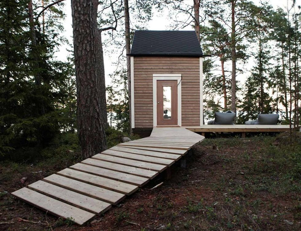 <p>Una plataforma de listones de madera sin tratar conduce a la entrada de la vivienda.</p>