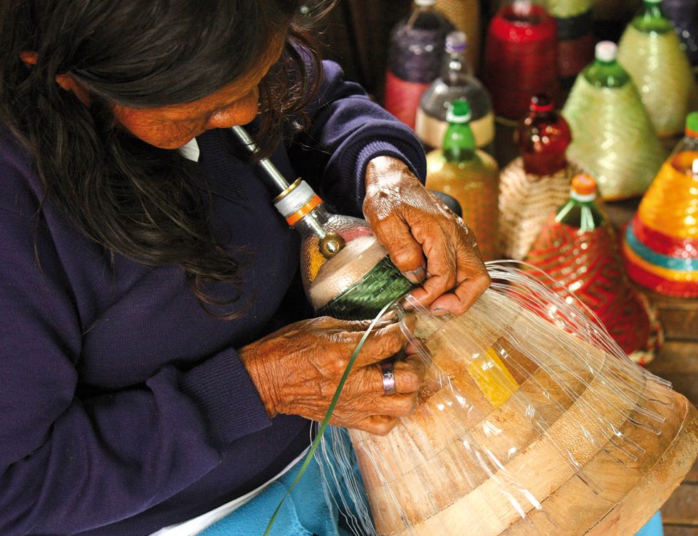 <p>Manuela Dura tejiendo una de las lámparas.</p>