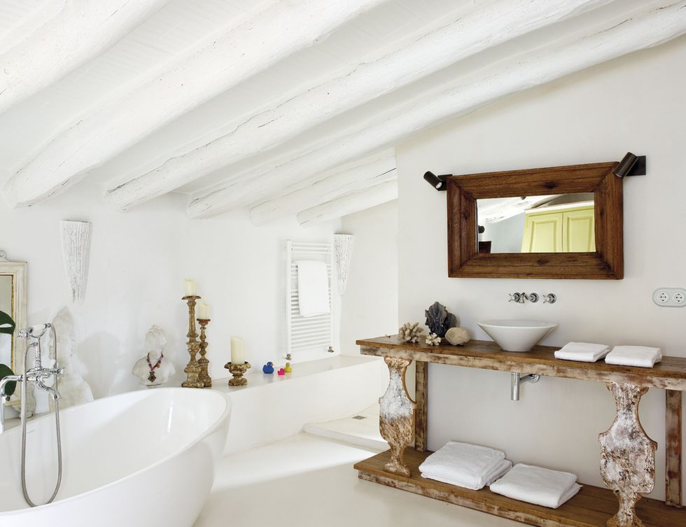 <p>Una bañera de Victoria and Albert; el mueble y el espejo de madera, de Azul Tierra.&nbsp;</p>