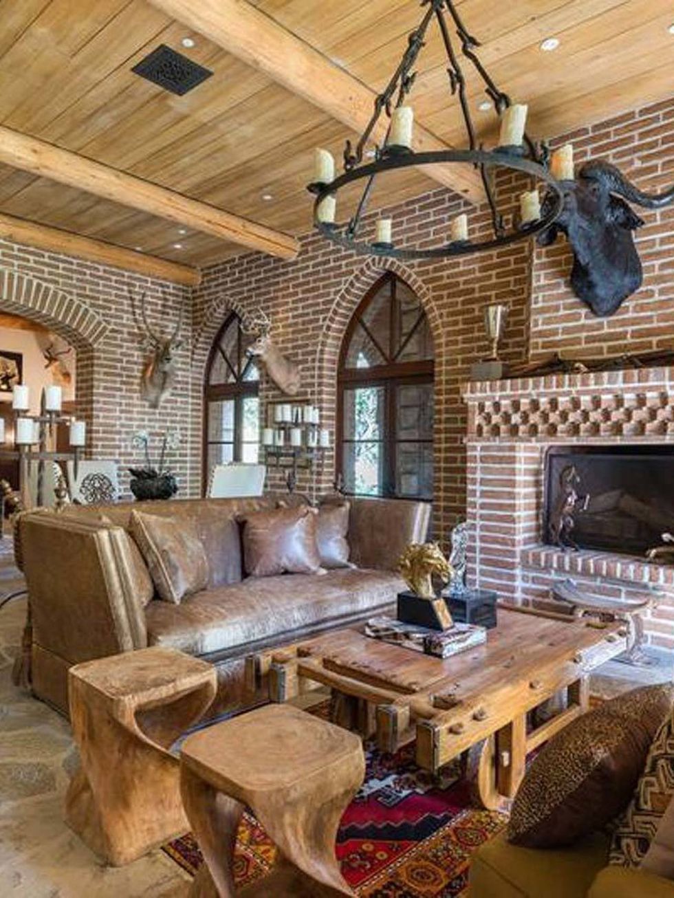 <p>La sala de estar posee una decoración que recuerda al medievo; la lámpara de hierro con velas, la piedra o las mesas en madera.</p>