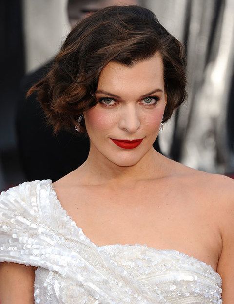 <p>La espectacular<strong> Milla Jovovich</strong> acertó con unas ondas laterales y labios en rojo mate, el look ideal para su Elie Saab blanco.</p>