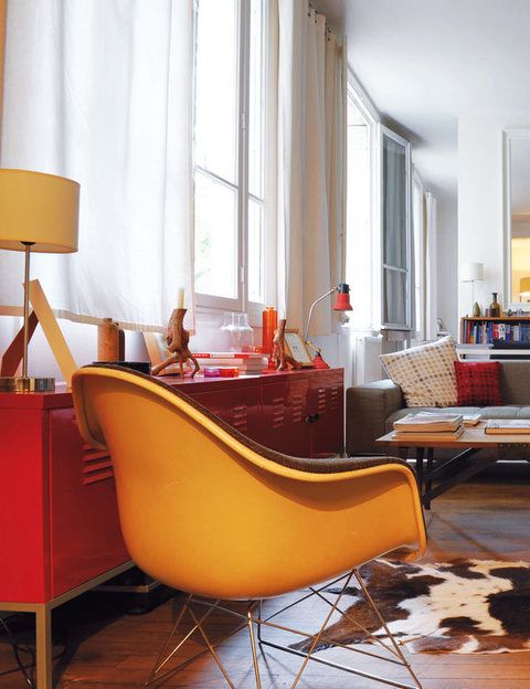 <p>A cargo de la <i>Plastic</i> y la <i>Rocking chair,</i> de los Eames, editadas por Vitra, y de los armarios de metal rojos, de Ikea. La alfombra es de piel de cabra.</p>