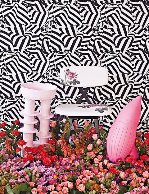 <p>Composición floral de  Soanesbury Flower School  (flores similares en Sia).  En la pared, tela Riviera Jais,  82 €/m, colección Arles de  Christian Lacroix para Designers Guild en Usera Usera. Jarrón rosa, de Soanesbury; silla  5 O’Clock Chair, 608 €, de Nika Zupanc para Moooi, y gnomo Baddy, 95 €, de Joe Velluto (JVLT) y A. Fabbian para Plust Collection. </p>