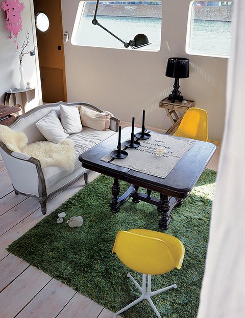 La zona de estar se ilumina con una lámpara de mesa articulada Jieldé sujeta al techo. Sobre una mesita, lámpara Bourgie, de Ferruccio Laviani para Kartell.