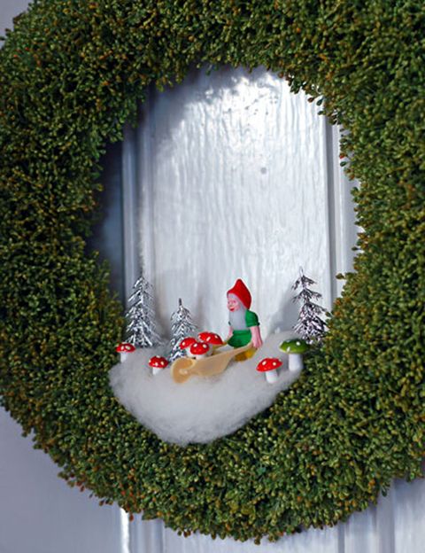 <p>Una buena idea es decorar la puerta de casa con una bonita corona. Y, si además le añades un poco de nieve, unos árboles, unas setas y un gnomo... ¡queda perfecto!</p>