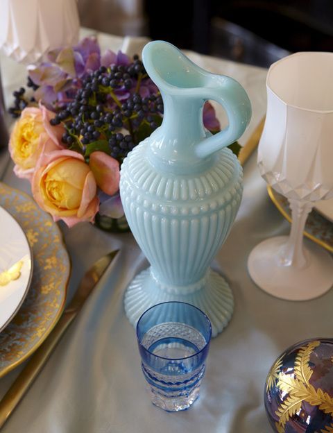<p>Este&nbsp; jarrón azul es de Habitat y aporta calma al centro de la mesa. El vaso de chupito de Cristalerías de Saint Louis.</p>