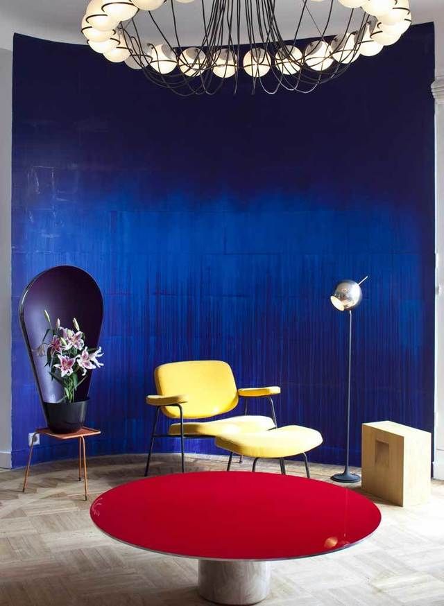 <p>En el salón, la gran tela azul que viste la pared es un trabajo de Latifa Echakhch; delante destaca un gran jarrón negro de los Bouroullec.</p>