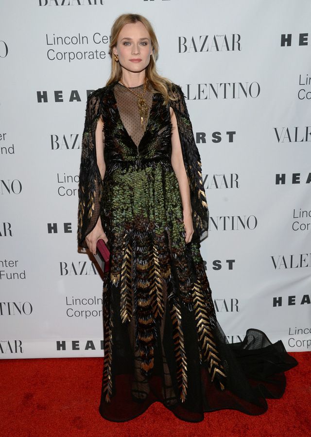 <p>Espectacular <strong>Diane Kruger</strong> con un vestido capa con plumas y transparencias en negro, verde y dorado.</p>