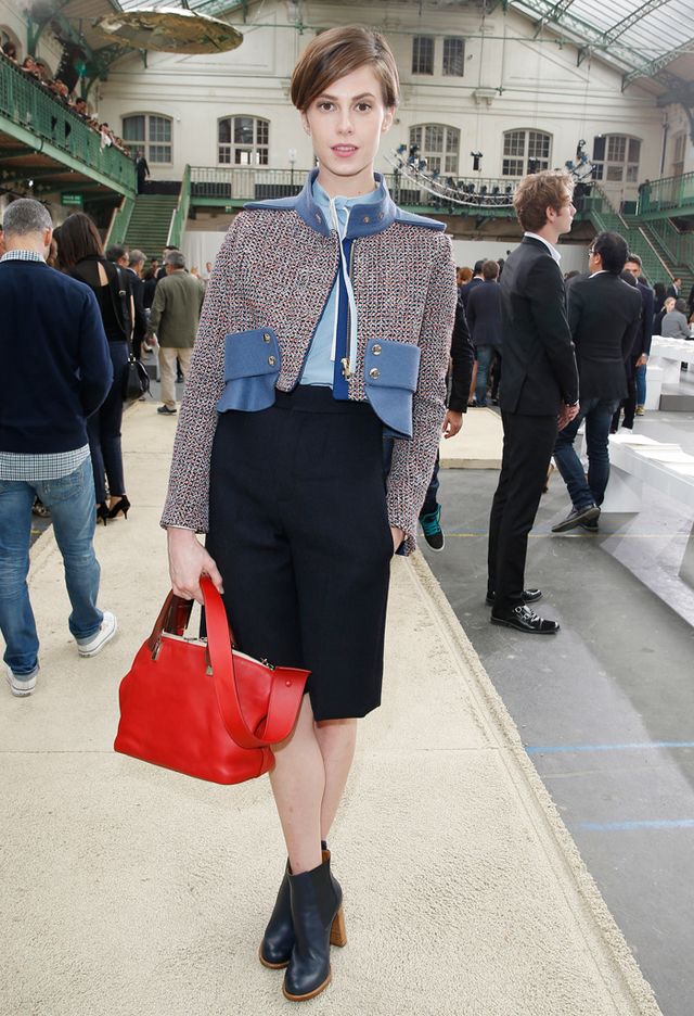 <p>La modelo acudió a la Semana de la Moda de París con una chaqueta corta de <i>tweed</i> con cuello y bolsillos con tachas, pantalón corto de talle alto y botines. Contrastó los colores fríos del <i>look</i> con el rojo del <i>tote bag.</i></p>