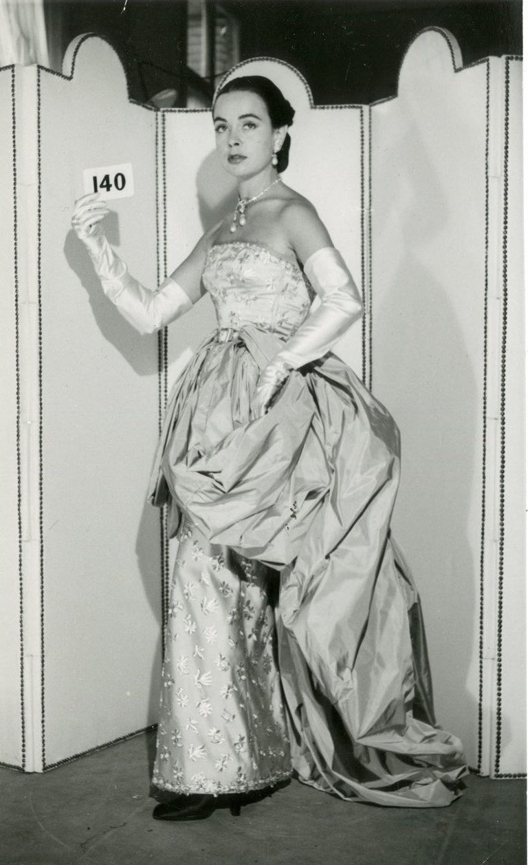 <p>Esta fotografía inmortaliza a una modelo de la época, que luce uno de los vestidos icónicos de <strong>Balenciaga</strong>. Confeccionado en 1951, se trata de una pieza muy admirada porque está inspirada en el vestido que vemos en la obra del pintor&nbsp;<strong>Francisco de Zurbarán, '</strong><strong>Santa Isabel de Portugal'</strong>&nbsp;(Museo Nacional del Prado).</p>