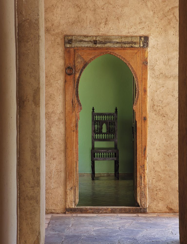 <p>La puerta en arco lleva a un despacho decorado en verde. Al fondo, una silla marroquí.&nbsp;</p>