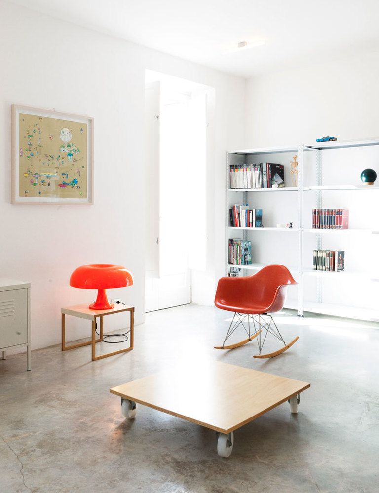 <p>La ausencia de piezas marca el salón, que se encuentra en la primera planta de la casa: tan solo hay una mesa con ruedas, la <i>Eames Plastic chair,</i> de Vitra, y una librería de estilo industrial.</p>
