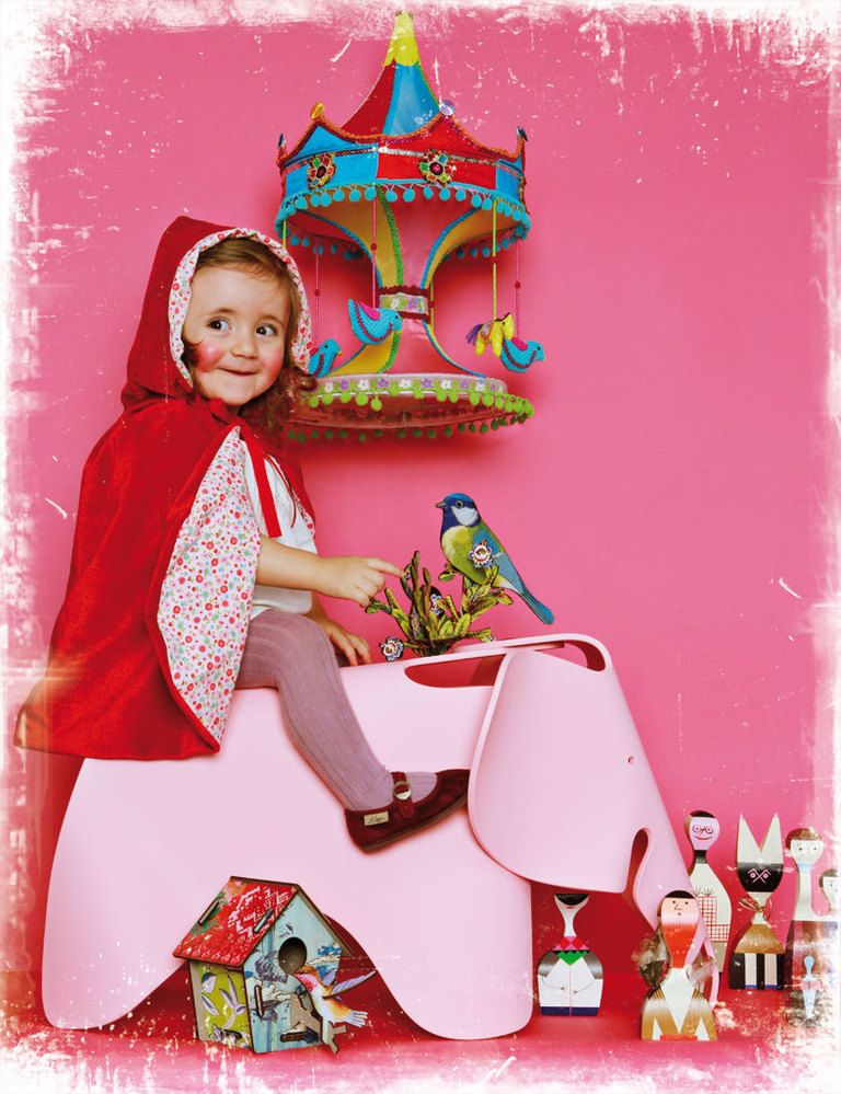 <p>Nuestra pequeña protagonista, Micaela, luce con estilo su disfraz de <a href="http://www.belandsoph.com/" target="_blank">Belandsoph.com</a>, 68 €, montada en  el elefante rosa Eames Elephant, 203 €, de los Eames en Vitra. El carrusel de la pared, 201 €, en Usera Usera. En el suelo, varias  figuritas de madera modelo <i>Dolls,</i> de Alexander Girard, 108 €/cu, de Vitra; pajarito desmontable y casita decorada desmontable,  ambos diseñados por Miho, 23 €/cu, de&nbsp;<a href="http://www.belandsoph.com/" target="_blank">Belandsoph.com</a>. En este cuento, no hay lobo feroz y el mundo es de color rosa.&nbsp;</p>
