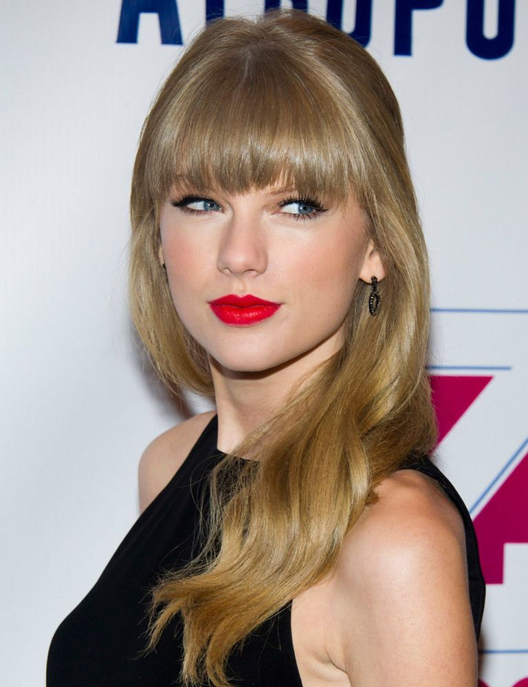<p><strong>Taylor Swift</strong> combina un flequillo espeso con una melena con ondas. La cantante añade un toque 'pin-up' con labios mate y rabillo de ojos negro.</p>
