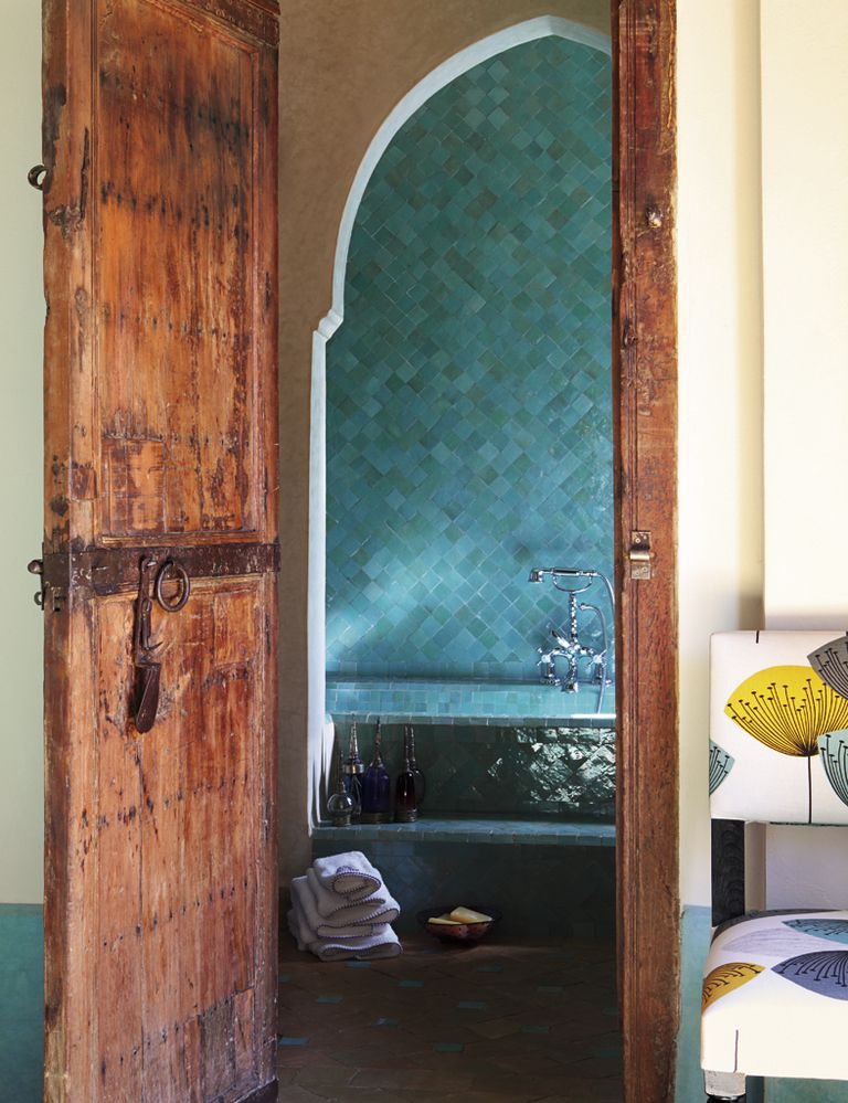 <p>Evoca el mar y es un color ideal para los azulejos que revisten este baño, uno de los nuevos que se hicieron con la reforma. La puerta de madera es original de la casa. La grifería es de Roca y las toallas bordadas, de Scenes de Lin. Telas, de Sanderson en Gancedo, retapizan la silla.</p>