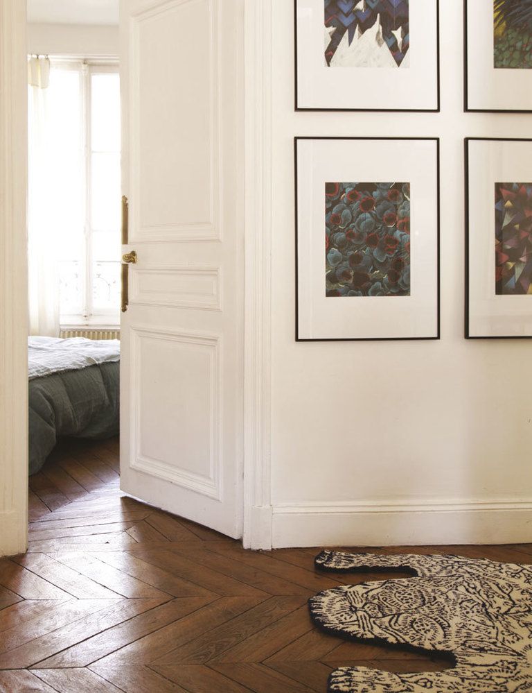 <p>Una alfombra con dibujo de tigre, de Dylan Martorell para Moustache, en Smallable, vigila la entrada al dormitorio principal. Las láminas de la pared son de Julien Colombier, en Galerie OFR.</p>
