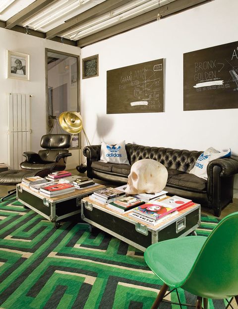 <p>El salón se ha  decorado con piezas recicladas, como los dos <i>flight cases</i> que componen la mesa de cento, y muebles de diseño, como la <i>Lounge Chair,</i> de Charles Eames para Vitra. La lámpara de pie  es de Habitat y, sobre la alfombra  de BSB, un sofá chéster de El Rastro.</p>