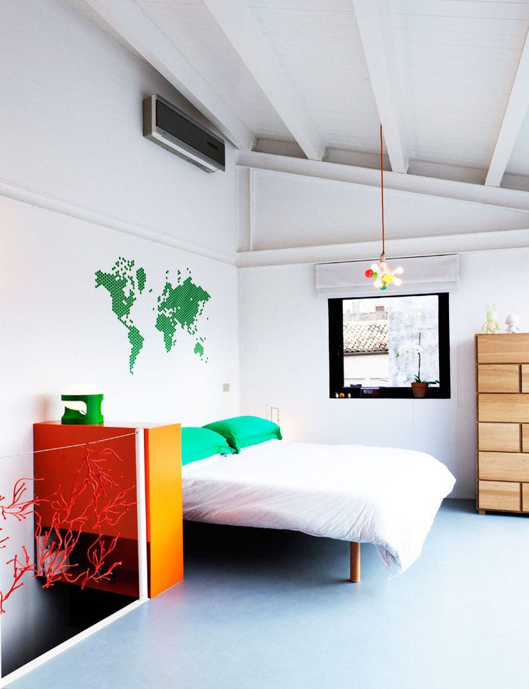 <p>Un mapamundi decora la pared de la cama, vestida de forma sencilla. La misma simplicidad marca la elección de materiales: cemento pulido en el suelo y techo entrevigado de madera.</p>