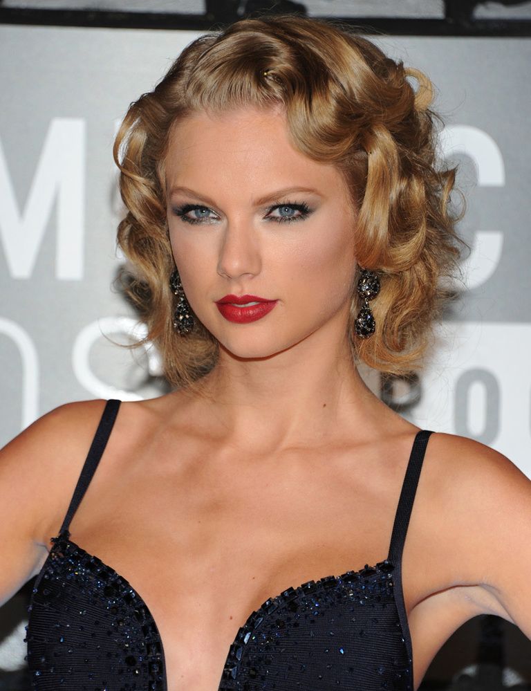 <p>La cantante <strong>Taylor Swift</strong> escogió un estilismo muy 'sexy' con el cabello suelto y rizado y labios en rojo. Además, Taylor ahumó su mirada con dos tonos de sombra metalizada: negro y color plata.</p>