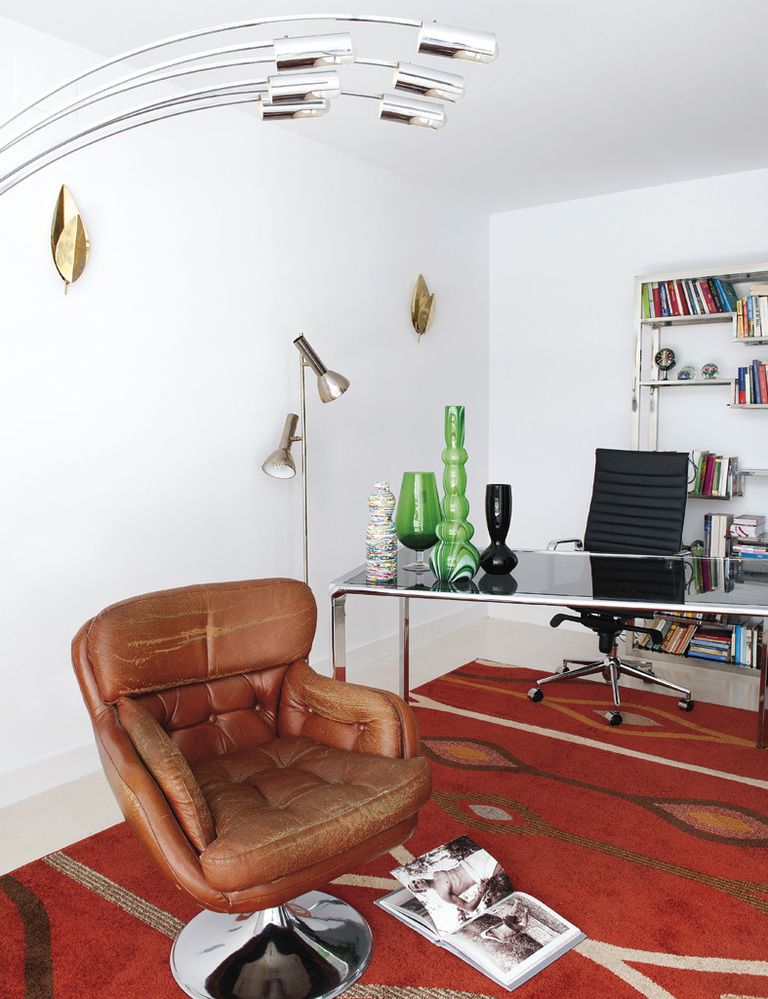 <p>El despacho se ha equipado con míticas piezas, como la Aluminium Chair, de Charles &amp; Ray Eames, y otros muebles de diseño, como la estantería, de Milo Baughman, o la butaca giratoria de cuero, de Henry W. Klein. Los apliques dorados de la pared son de Tommaso Barbi.</p>