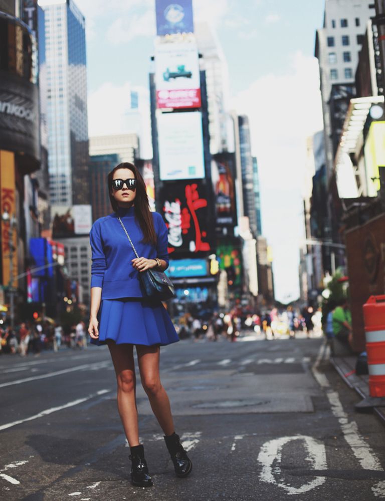 <p>Andy Torres posa en Times Square con un sencillo conjunto de sudadera azul y minifalda de neopreno tableada azul, y escoge complementos en negro para crear un leve contraste.</p>