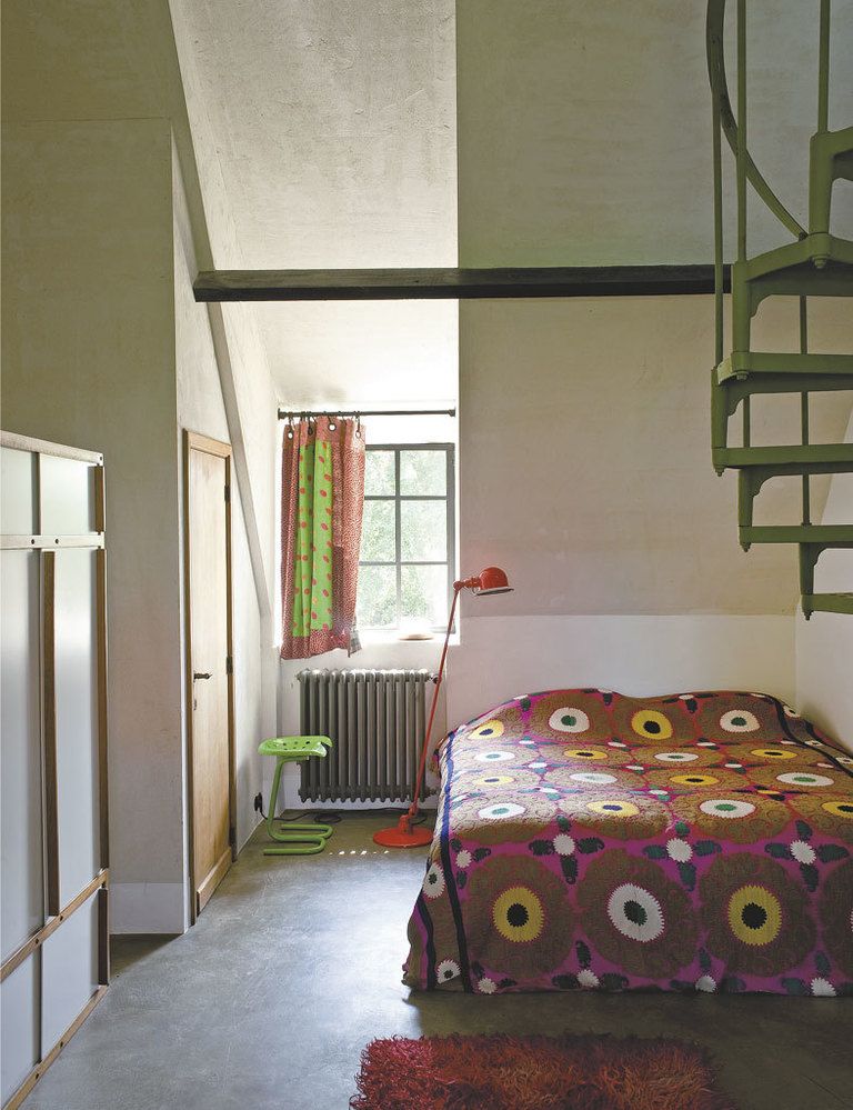 <p>En uno de los dormitorios, sobre la cama, suzani de Afganistán; taburete  verde, de Joe Colombo; lámpara Jieldé de Jean Louis Domecq; armario vintage, de André Sornay.</p>