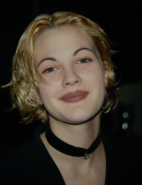 <p>La suma 'cejas mínimas más labial marrón' de <strong>Drew Barrymore</strong> define como ninguna el estilo de los 90. Como también lo hace su gargantilla de tejido pegada al cuello</p>