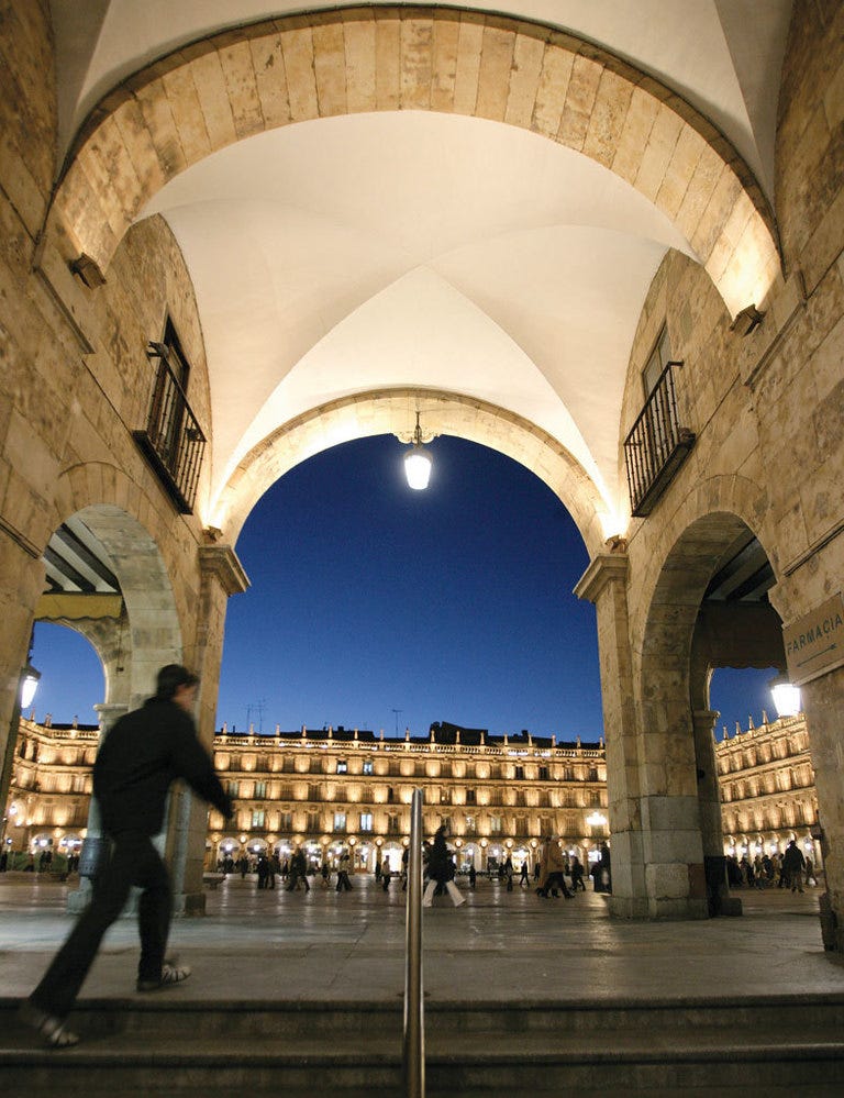 <p>Sus medidas no son perfectas –se evitó darle una forma rectangular por respeto a la iglesia de San Martín– y la piedra dorada con que se construyó, proveniente de las canteras de Villamayor, era una de las más habituales de la zona. Aún así, la plaza Mayor salmantina es una de las grandes manifestaciones del estilo churrigueresco, la variante menos minimalista del barroco. Tras librarse de sus urinarios, su quiosco de música y sus jardines, la antigua plaza de San Martín quedó diáfana, arropada por sus arcos y con una sobriedad castellana que enamoró a numerosos artistas. Unamuno definió este espacio como &quot;irregular, pero asombrosamente armónico&quot;, una opinión en la que, años antes, coincidió Chueca, cuando la definió como &quot;la más bella de España&quot;. Si vienes de noche, te encantará su iluminación nocturna, que dibuja juegos de luces sobre el pavimento, y su ambiente universitario. Infórmate en <a href="http://www.salamanca.es" target="_blank">www.salamanca.es</a>.</p>